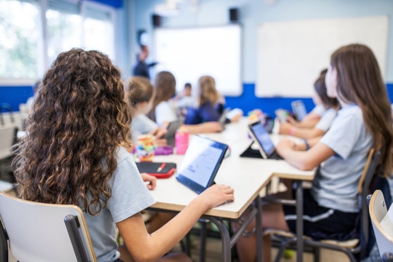 young students in a classroom using tablets